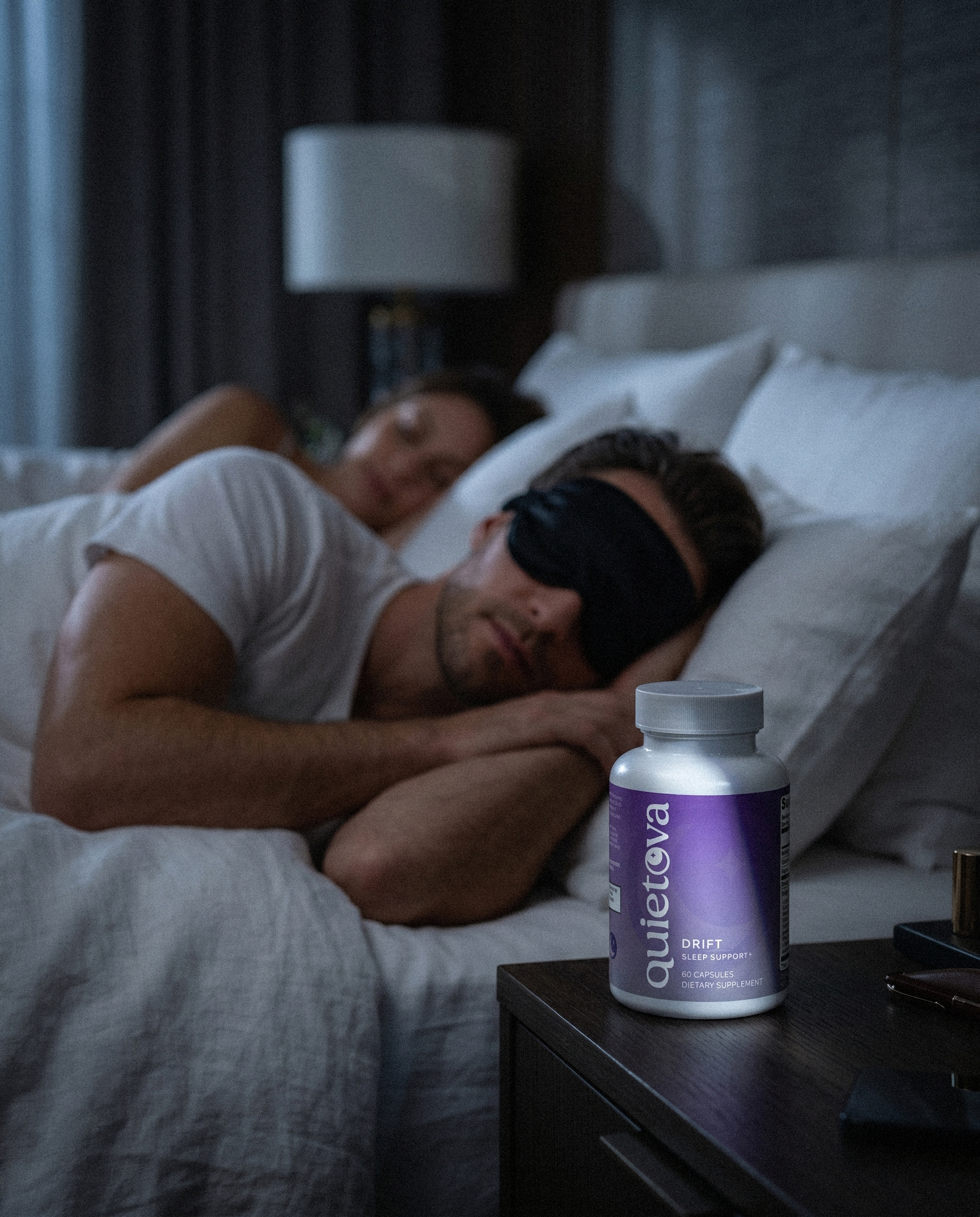 Man sleeping peacefully with a Quietova Drift bottle on the nightstand